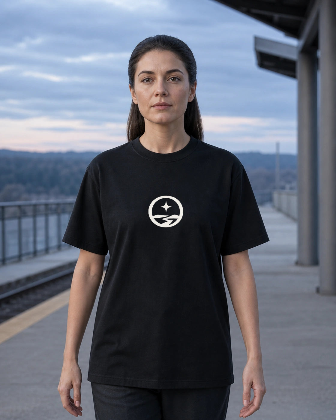 Model outdoors wearing the Somewhere Journey Mark tee in Black, front view